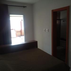 a bedroom with a bed and a mirror and a door at Apartamento alto padrão vista mar in Praia Grande