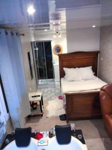Un dormitorio con una cama y una mesa y sillas. en Chambre meublée indépendante, jacuzzi dans la chambre à 60110 Amblainville près de Paris, en Amblainville