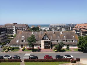 a large building with cars parked in a parking lot at T2 vue mer 6 personnes in Villers-sur-Mer