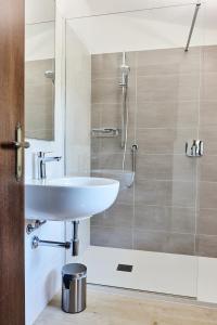 une salle de bain avec un lavabo et une douche dans l'établissement Appartamenti Hopfen Lazise, à Lazise