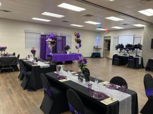 Habitación con mesas y sillas con flores púrpura y púrpura en Howard Johnson by Wyndham Ocala FL I-75, en Ocala