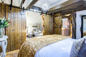 1 dormitorio con 1 cama y paredes de madera en Unique Cottage The Old Stables Pembrokeshire Sleeps 8 - Welsh Tourist Board Award 5 Stars, en Pembroke