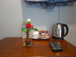 a table with a vase of flowers and a coffee pot at Tea Mount Forest in Nuwara Eliya