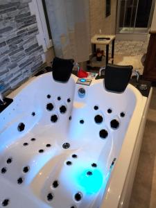 Dos sillas sentadas en una bañera en un baño. en Chambre meublée indépendante, jacuzzi dans la chambre à 60110 Amblainville près de Paris, en Amblainville