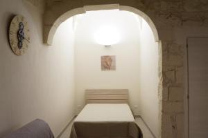 - une petite chambre avec un lit dans une pièce dotée d'une fenêtre dans l'établissement CASETTA SALVATORE, à Ostuni
