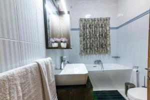 La salle de bains blanche est pourvue d'une baignoire et d'un lavabo. dans l'établissement Rua Cosy Apartment Sliema (3 Bedroom 2 Bathroom), 2 mins walk from sea, à Sliema
