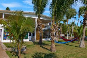 a hammock in front of a house with palm trees at Hotel Villa Murano in Puerto Arista