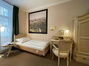 ein Schlafzimmer mit einem Bett, einem Tisch und einem Stuhl in der Unterkunft U Cervene zidle - Red Chair Hotel in Prag