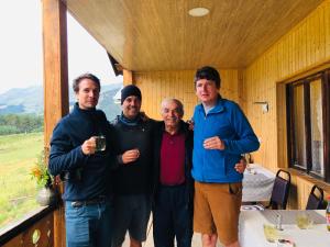 a group of four people posing for a picture in a cabin at Guest House Gere in Omalo