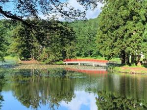 een uitzicht op een meer met een brug en bomen bij Koguriyama Sanso - Vacation STAY 43384v in Minami Uonuma