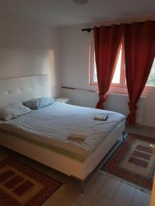 sypialnia z dużym łóżkiem z czerwonymi zasłonami w obiekcie Apartman VENERA w Sarajewie
