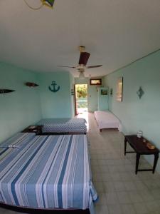 a large room with two beds and a table at A Pousada. in Barra dos Coqueiros