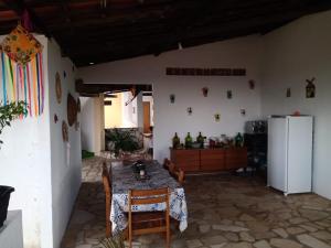 a kitchen with a table with chairs and a refrigerator at Refúgio da Mangueira in Barra dos Coqueiros