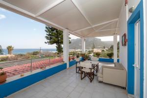 a balcony with a table and chairs and a view of the ocean at Villa Giorgos in Kefalos