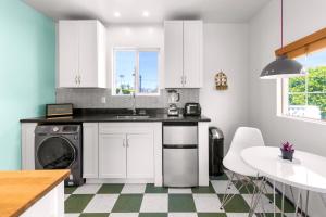 a kitchen with white cabinets and a sink and a dishwasher at Saint Boniface Hotel in Indio