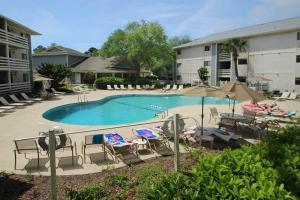 a large swimming pool with chairs and umbrellas at Fiddlers Cove in Hilton Head Island