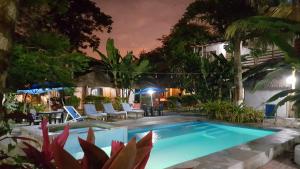a swimming pool in a yard at night at Hotel Sumpa in Montañita +24 photos