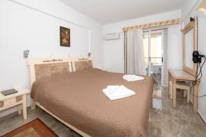 a bedroom with a bed and a desk and a window at Villa Giorgos in Kefalos
