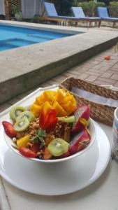 a plate of fruit on a table next to a pool at Hotel Sumpa in Montañita
