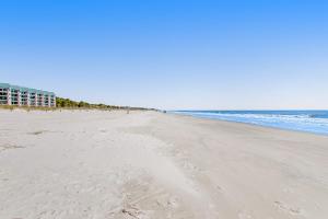 una playa con huellas en la arena y el océano en Fiddlers Cove, en Hilton Head Island