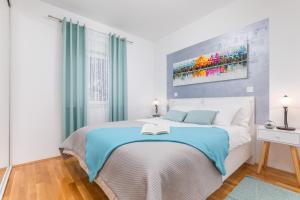 een slaapkamer met een groot bed en een blauwe deken bij Apartment Mila in Fažana