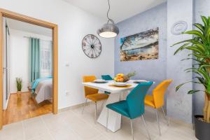 een eetkamer met een witte tafel en stoelen bij Apartment Mila in Fažana
