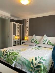 1 dormitorio con 1 cama grande con colcha tropical en Haus Übernachtenswert Cochem Mosel, en Cochem