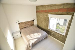 a bedroom with a bed and a brick wall at LAS MARAS SUITES in Viedma