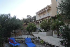 a house with two chairs and a table in front of it at Kalliroe Apartments -Creta in Agia Galini