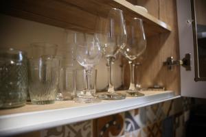 a row of wine glasses sitting on a shelf at Apartment Nola in Porozina
