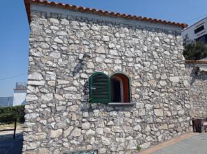 ヴィーコ・エクエンセにあるVilla Mami Lurovigaの緑のシャッター付きの窓のある石造りの建物