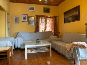 a living room with two couches and a table at Athena’s House in Elaión