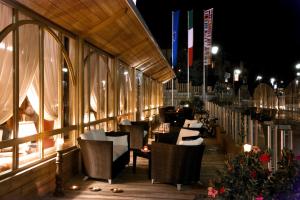 a restaurant with tables and chairs on a balcony at night at Alpen Suite Hotel in Madonna di Campiglio