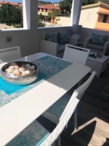 a white table with a bowl of mushrooms on it at Casa Babila 100 metres from the beach 10 kilometres from Villasimius in Solanas