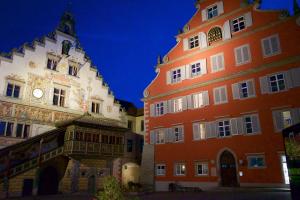 two tall buildings next to each other with a clock tower at Hotel Alte Schule Lindau in Lindau