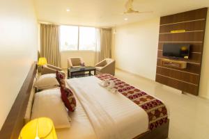a hotel room with a large bed and a television at Miracle Residency in Kizhake Chālakudi