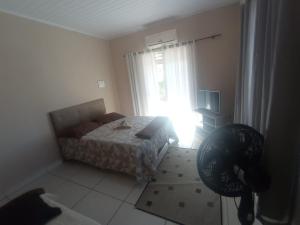 um quarto com uma cama e uma janela com a entrada do sol em APTO do JOCKEY Galdino em Campos dos Goytacazes