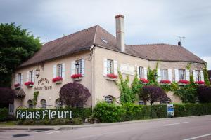 un edificio con flores en la parte delantera en Logis Le Relais Fleuri en Sauvigny-le-Bois