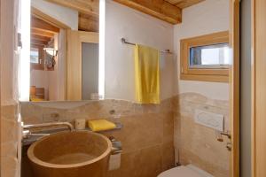 une salle de bain avec un lavabo, des toilettes et un miroir dans l'établissement Chalet Alpoase, à Zermatt 12 autres photos