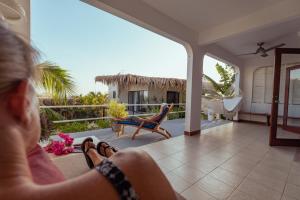 a woman sitting on the porch of a house at Casas Kismet in Nosara