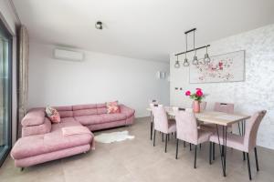 a living room with a pink couch and a table at Luxury Apartment Sea in Pakoštane +37 photos