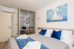 a bedroom with a large bed with blue and white pillows at Luxury Apartment Sea in Pakoštane