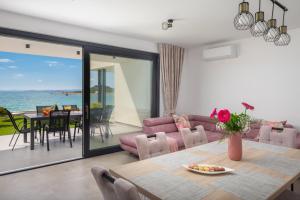 a living room with a table and chairs and the ocean at Luxury Apartment Sea in Pakoštane