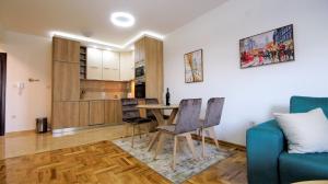 ein Wohnzimmer mit Tisch und Stühlen und eine Küche in der Unterkunft Aleksa Lux apartment Budva in Budva