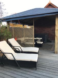 a group of lounge chairs sitting on a deck at Grooms cottage in Thornton
