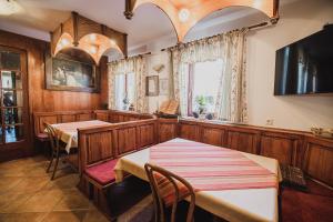 a dining room with two tables and a tv at Homestay Kocka in Zgornje Jezersko