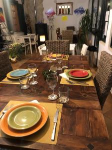 una mesa de madera con platos y copas de vino. en Breezes B&B en Conca Specchiulla