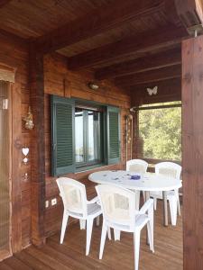 a porch with a white table and white chairs at CHALET REGINA in Paradhísion +32 photos