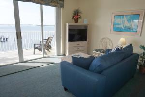 a living room with a blue couch and a television at Boca Ciega Resort by Travel Resort Services in St Petersburg
