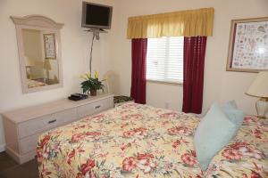 a bedroom with a bed and a dresser and a mirror at Boca Ciega Resort by Travel Resort Services in St Petersburg +27 photos